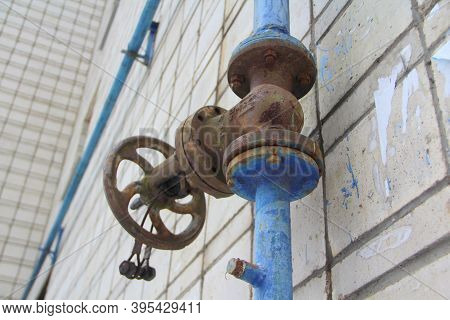 Old Damaged And Rusty Iron Oil Pipe Valve Wheel. Metal, Pipeline And Mechanic Concept. An Old Iron V