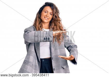 Young hispanic woman with tattoo wearing business oversize jacket gesturing with hands showing big and large size sign, measure symbol. smiling looking at the camera. measuring concept. 