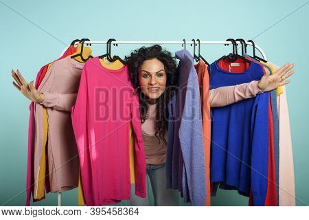 Woman Chooses The Clothes To Buy In A Store. Concept Of Shopping And Shopaholic.