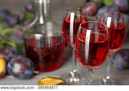 Delicious Plum Liquor And Ripe Fruits On Table, Closeup. Homemade Strong Alcoholic Beverage