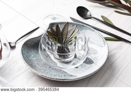Elegant Table Setting With Floral Decor On White Wooden Background