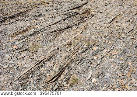 Abstract Close-up Of Layered Parellel Rocks And Gravel On Ground.