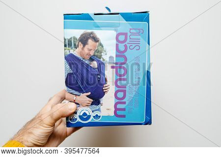 Paris, France - Nov 11, 2020: Pov Male Hand Holding Package Of New Manduca Sling For Baby - Isoalted