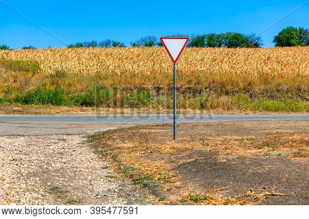 Country Road And Agricultural Field . Road Sign Give Way