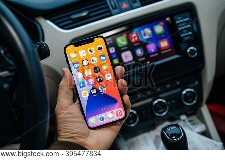 Paris, France - Nov 11, 2020: Male Hand Holding New Iphone 12 Pro With Icons Of Infotainment Car Com