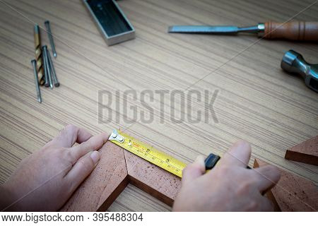 Close Up View Of A Woman's Hands Measuring Wooden Plank With A Tape Measure With A Set Collection Of
