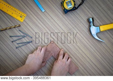 Carpenter Hands Measuring Wood Plank With A Set Collection Of Working Hand Tools For The Wooden, Too