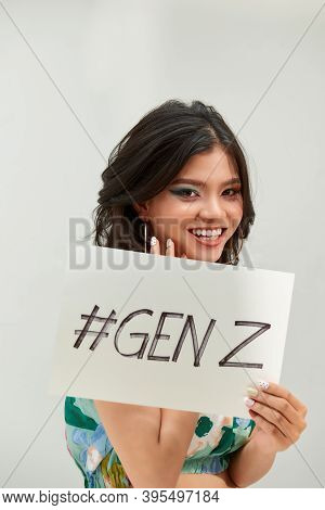 Young Millennial Teenage With A Funny Expression, Holds A Sign With The Text 