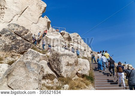Uchisar, Turkey - October 4, 2020: Unidentified People Climb A Tuff Rock (uchisar Castle), Cut By Ca