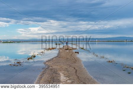 Flooded Road Under The Cloudy Sky And Tourists Taking Selfie