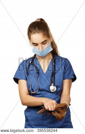 Young Female Doctor In Blue Coat Getting Ready For Work Putting On Protective Brown Surgical Gloves