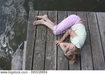 A Sad Little Child Lies On The Floor. The Concept Of Isolation, Loneliness, Running Away From Proble