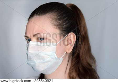 Young Woman Demonstrates Hot To Properly Wear A Face Mask Covering Mouth, Nose And Chin, To Prevent 