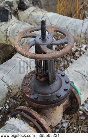 Old Damaged And Rusty Iron Oil Pipe Valve Wheel. Metal, Pipeline And Mechanic Concept. An Old Iron V