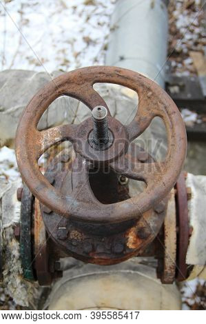Old Damaged And Rusty Iron Oil Pipe Valve Wheel. Metal, Pipeline And Mechanic Concept. An Old Iron V