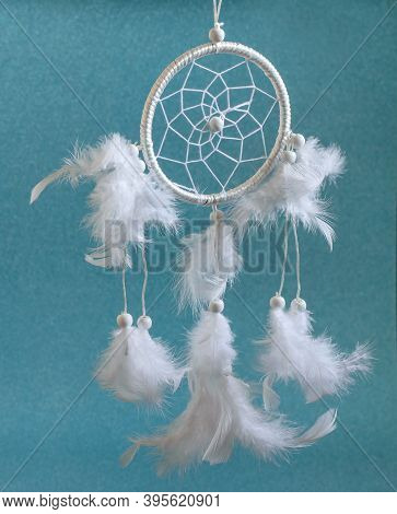 White Beautiful Magic Wheel Dreamcatcher With Feathers On The Blue Background. Ethnic Amulet Of Nati
