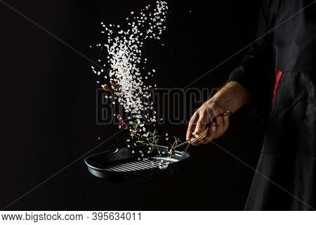 Cooking Roasted Aromatic Salt In A Pan By Chef Hand Of Rosemary, Dried Pepper Chili. Banner, Caterin