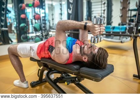 Young Dark-haired Man Working On His Body In Gym