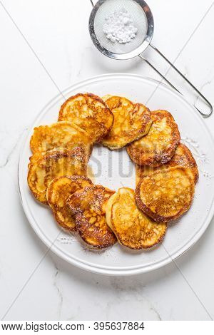Homemade low calarie curd cheese pancakes on white plate.
