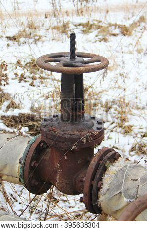 Old Damaged And Rusty Iron Oil Pipe Valve Wheel. Metal, Pipeline And Mechanic Concept. An Old Iron V