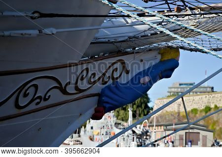 Blue Female Figurehead On The Bow Of An Old Tall Ship By The Docks.