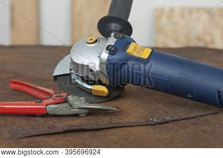 Angle Grinder With Thinner Cut-off Disc And Red Shears For Cutting Metal On  Old Rusty Metal Sheet.