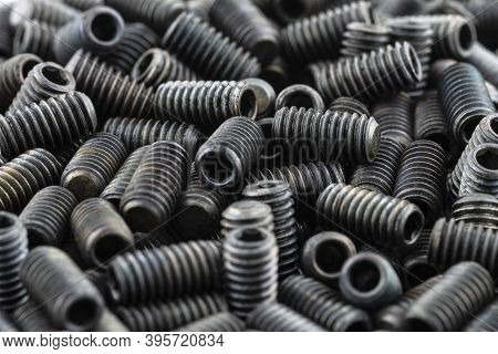 Background Made From A Macro Shot Of Scattered, Black Grub Screw On Table.