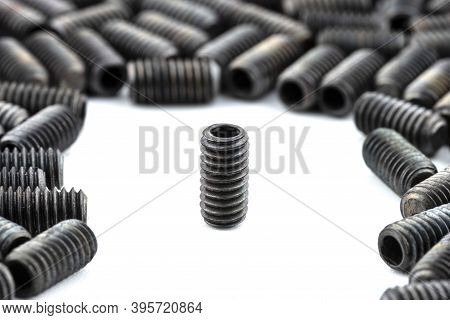 Background Made From A Macro Shot Of One Standing, Black Grub Screw On White Table.