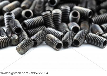 Background Made From A Macro Shot Of Scattered, Black Grub Screw On Table, Arranged In A Row At The 