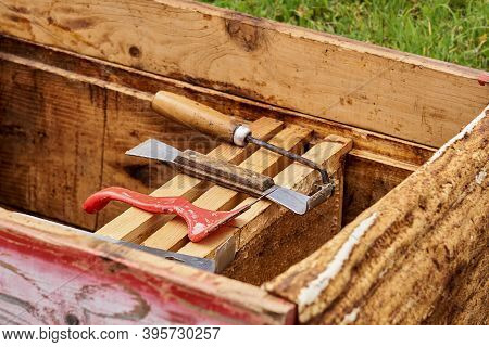 Beekeeper Tools Are Laid Out On Honeycomb Frames In An Opened Hive