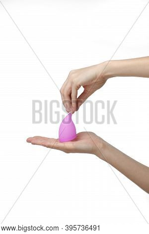 Young Woman Hand Holding A Pink Menstrual Cup - White Background. Gynecology Concept.