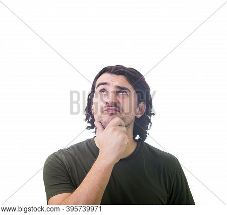 Portrait Of Doubtful Young Man, Keeps Hand Under Chin, Thoughtful Gesture, Looking Up Suspicious Iso