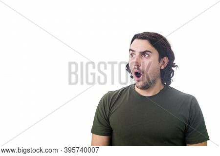 Portrait Of Stunned And Shocked Young Man, Long Curly Hair Style, Big Eyes Looks Aside Astonished Is