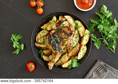 Spatchcocked Grilled Chicken With Potatoes On Plate On A Over Black Stone Background. Top View, Flat