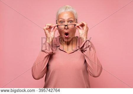 Surprised Senior Woman Looking Through Glasses Otices Something Unexpected,