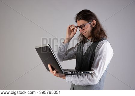 Programming And Writing Code, Developing Software Products. Geek Guy, With Long Hair And Glasses, Ho