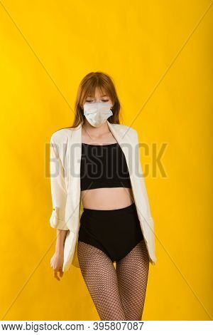 Female Strip Dancer In Yellow Studio In Protective Mask From Covid