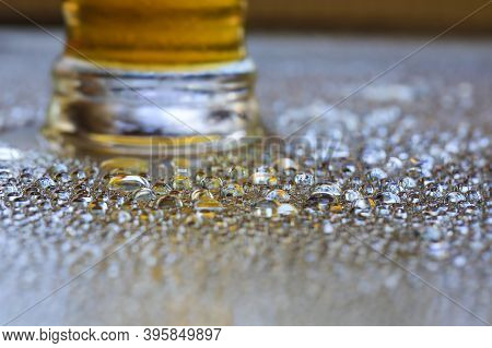 Big Bright Beer On The Glass Desk With Water Drops And Frost.