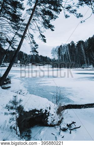 Cracks On The Surface Of The Blue Ice. Frozen Lake In Winter Mountains. It Is Snowing. The Hills Of 