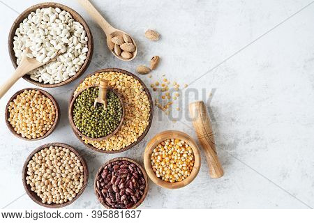 Various Dried Legumes In Wooden Bowls Top View Flat Lay On White Marble Background