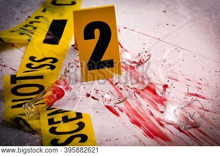Yellow Tape, Crime Scene Marker And Smithereens In Blood On Marble Table, Closeup