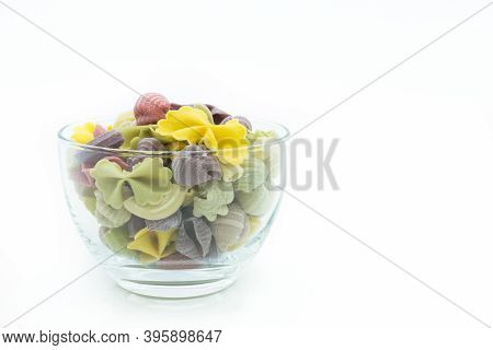 Close-up View Of The Colorful Macaroni  In Glass Bowl Isolated On The White Background.