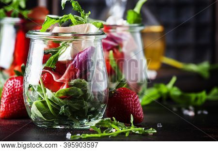 Fresh Salad With Spicy Arugula, Goat Cheese, Strawberry And Prosciutto Or Ham In Modern Glass Jars O