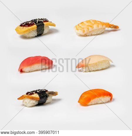 Set Of Different Types Of Nigiri Sushi On A Neutral White Background. Salmon, Eel, Shrimp, Squid And