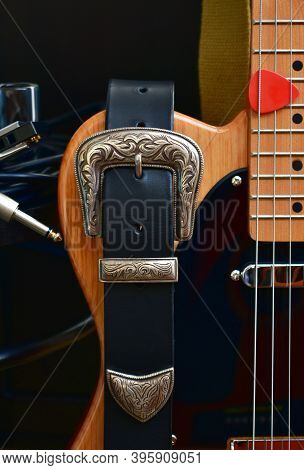 Electric Guitar And Leather Strap With Silver Buckle. Close-up With Glass Slide, Blues Harp, Cable J