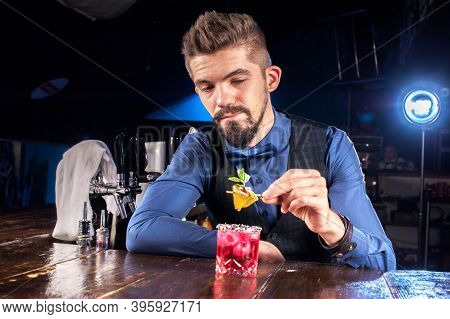 Young Barman Makes A Cocktail At The Bar Counter