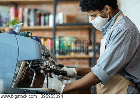 Professional Barista Works With Equipment In Cafe During Social Distancing. Millennial African Ameri