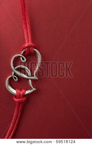 Two hearts connected, on red background.