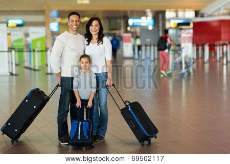 happy family with suitcases at airport