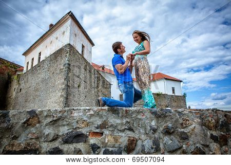 guy proposing marriage to the girlfriend against the old lock
